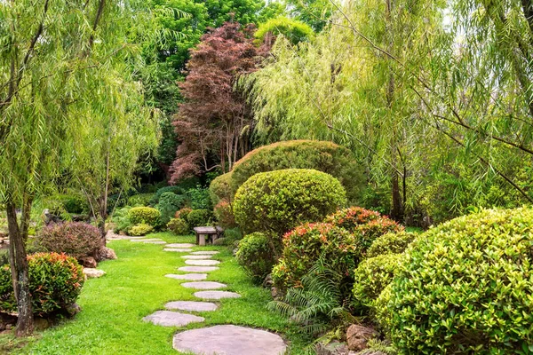 在日本风格的花园中 石头在草坪之间穿行 园中的景观 免版税图库照片
