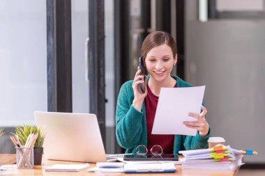 İş kadını ofisteki akıllı telefondan konuşuyor. İş gündelik konsepti.
