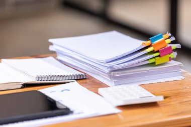 Kağıt belgeler işyerindeki ahşap masaların üzerine istiflenmiş. İş Konsepti.