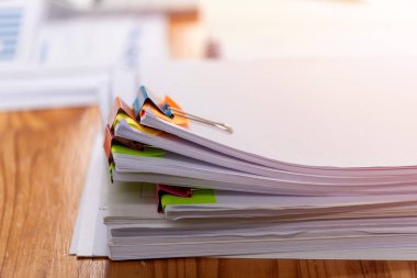 Kağıt belgeler işyerindeki ahşap masaların üzerine istiflenmiş. İş Konsepti.