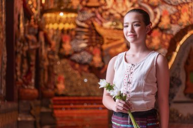 Geleneksel kostümler giyen Taylandlı genç bir kız Tayland, Chiang Mai 'deki Sridonmoon tapınağını ziyaret ediyor. Tayland Tapınağı 'nda geleneksel kostümlü Asyalı gençler.