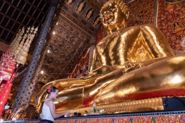 Geleneksel kostümler giyen Taylandlı genç bir kız Tayland, Chiang Mai 'deki Sridonmoon tapınağını ziyaret ediyor. Tayland Tapınağı 'nda geleneksel kostümlü Asyalı gençler.