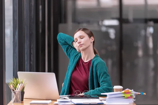 Young businesswoman office worker stretching lazily and forth relieves pain at office table workplace, feeling overworked. office syndrome concep