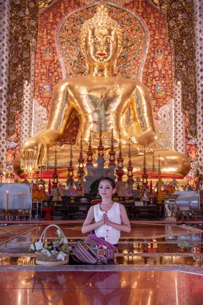 Geleneksel kostümler giyen Taylandlı genç bir kız Tayland, Chiang Mai 'deki Sridonmoon tapınağını ziyaret ediyor. Tayland Tapınağı 'nda geleneksel kostümlü Asyalı gençler.