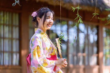 Geleneksel Japon kimonosu ya da yukata giyen genç kadınlar parkta mutlu ve neşelidir. Japon geleneksel yaz elbisesi.