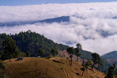 Kuzey Tayland 'da, Ba Lu Kho View Piont, Mae Chaem, Chiang Mai' deki dağlarda puslu bir sabahın manzarası. Alçak bulutlar ve sis yeşil orman üzerinde yuvarlanıyor, sis denizi.