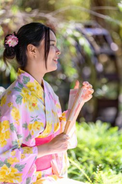 Geleneksel Japon kimonosu ya da yukata giyen genç kadınlar parkta mutlu ve neşelidir. Japon geleneksel yaz elbisesi.