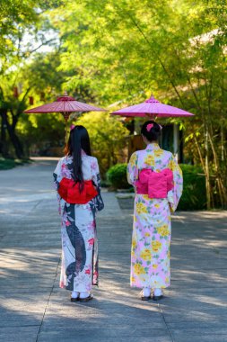 Japon Yukata 'sı takan ve elinde kağıt şemsiye tutan genç bir kadının arka görüntüsü. Japon geleneksel yaz elbisesi.