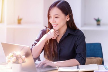 Ofiste dizüstü bilgisayarın önünde çalışan bir iş kadını. Ticaretin gelişigüzel ve başarılı kavramı