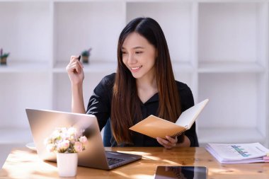 İnternette çalışan iş kadınları ofiste dizüstü bilgisayarın önünde buluşuyorlar. Ticaretin gelişigüzel ve başarılı kavramı