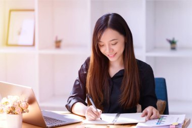 Ofiste dizüstü bilgisayarın önünde çalışan bir iş kadını. Ticaretin gelişigüzel ve başarılı kavramı