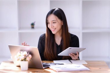 İnternette çalışan iş kadınları ofiste dizüstü bilgisayarın önünde buluşuyorlar. Ticaretin gelişigüzel ve başarılı kavramı