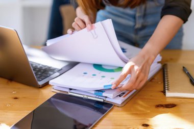 İş yerindeki ahşap masalardaki kağıt yığınlarında arama yapmak. Ticaretin gelişigüzel ve başarılı kavramı.