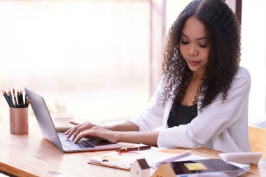 Ofiste dizüstü bilgisayarın önünde çalışan bir iş kadını. Ticaretin gelişigüzel ve başarılı kavramı