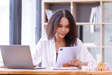 İş kadını çalışma masasında bir tablet kullanıyordu. İş gündelik konsepti.