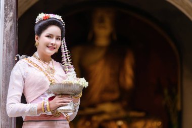 Geleneksel Kuzey Tayland kültürü kostümü giymiş genç bir Taylandlı kadın Tayland, Chiang Mai 'deki bir tapınağı ziyaret ediyor. Tayland Tapınağı 'nda geleneksel kostümlü Asyalı genç kadınlar