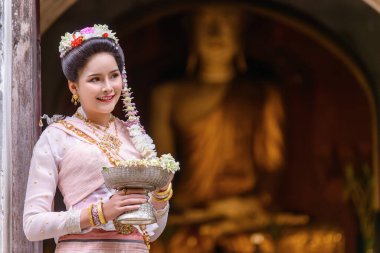 Geleneksel Kuzey Tayland kültürü kostümü giymiş genç bir Taylandlı kadın Tayland, Chiang Mai 'deki bir tapınağı ziyaret ediyor. Tayland Tapınağı 'nda geleneksel kostümlü Asyalı genç kadınlar