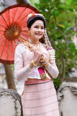 Geleneksel Kuzey Tayland kültürü kostümü giymiş genç bir Taylandlı kadın Tayland, Chiang Mai 'deki bir tapınağı ziyaret ediyor. Tayland Tapınağı 'nda geleneksel kostümlü Asyalı genç kadınlar
