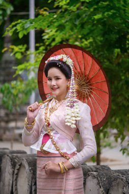 Geleneksel Kuzey Tayland kültürü kostümü giymiş genç bir Taylandlı kadın Tayland, Chiang Mai 'deki bir tapınağı ziyaret ediyor. Tayland Tapınağı 'nda geleneksel kostümlü Asyalı genç kadınlar