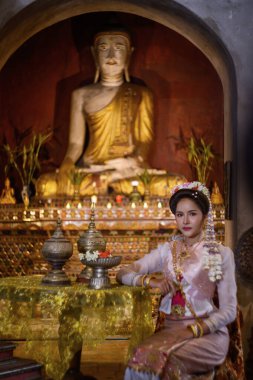 Geleneksel Kuzey Tayland kültürü kostümü giymiş genç bir Taylandlı kadın Tayland, Chiang Mai 'deki bir tapınağı ziyaret ediyor. Tayland Tapınağı 'nda geleneksel kostümlü Asyalı genç kadınlar