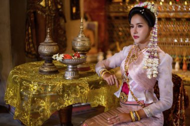 Geleneksel Kuzey Tayland kültürü kostümü giymiş genç bir Taylandlı kadın Tayland, Chiang Mai 'deki bir tapınağı ziyaret ediyor. Tayland Tapınağı 'nda geleneksel kostümlü Asyalı genç kadınlar