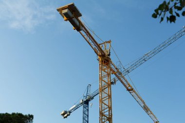 İnşaat alanında çalışan vinçler inşaat malzemelerinin taşınmasına yardımcı oluyor.