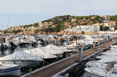 Sant Feliu de Gixols, Katalonya, İspanya 'daki rıhtıma demirlemiş küçük tekneleri olan Marina.