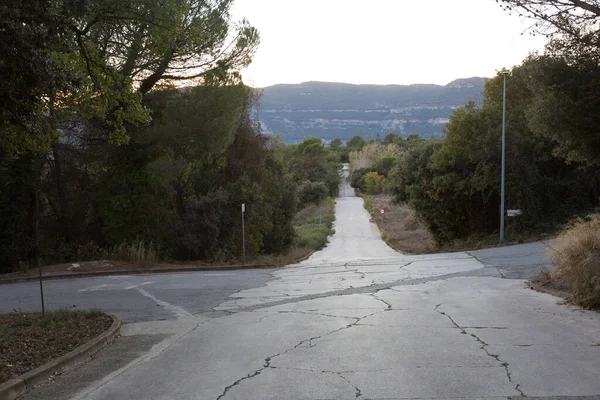 stock image straight and empty road between mountains at dusk