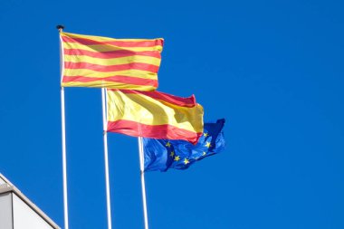 Flags fluttering in the wind under blue skies