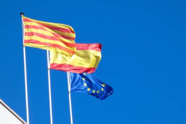 Flags fluttering in the wind under blue skies