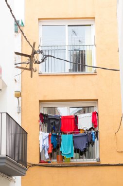Eski bir şehrin penceresinde asılı renkli giysiler.