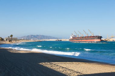 Kargo gemisi, küçük bir limanda yükleniyor.