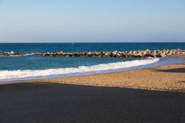 Kumlu bir sahil civarındaki kaya kırıntısı.