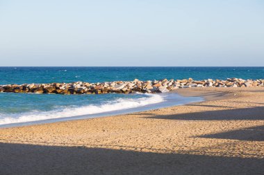 Kumlu bir sahil civarındaki kaya kırıntısı.