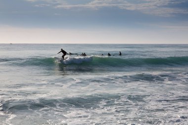 Birkaç sörfçü dalganın gelmesini bekliyor..