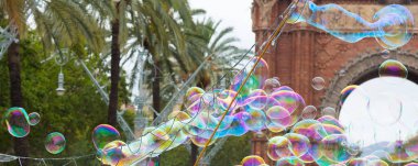 Sabun köpükleri yüzüyor ve şaşırtıcı renkleri yansıtıyor..