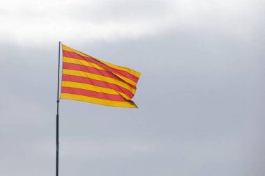 Bir kayanın tepesinde kırmızı ve sarı çizgili Katalan bayrağı