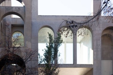 Yaratıcı açık gri beton kemerlerle dolu yapı, şekli tanımlayan sert gölgelerle, boşluklar ve odalar yaratıyor..