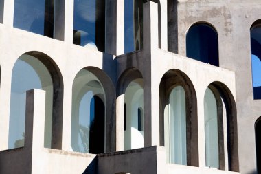 Yaratıcı açık gri beton kemerlerle dolu yapı, şekli tanımlayan sert gölgelerle, boşluklar ve odalar yaratıyor..