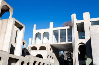 Yaratıcı açık gri beton kemerlerle dolu yapı, şekli tanımlayan sert gölgelerle, boşluklar ve odalar yaratıyor..