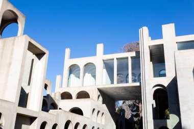 Yaratıcı açık gri beton kemerlerle dolu yapı, şekli tanımlayan sert gölgelerle, boşluklar ve odalar yaratıyor..