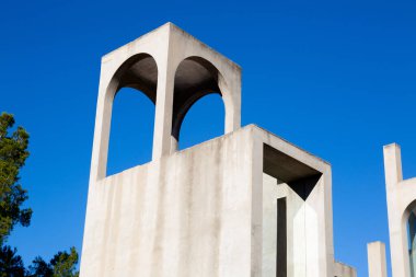 Yaratıcı açık gri beton kemerlerle dolu yapı, şekli tanımlayan sert gölgelerle, boşluklar ve odalar yaratıyor..