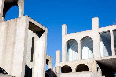 Yaratıcı açık gri beton kemerlerle dolu yapı, şekli tanımlayan sert gölgelerle, boşluklar ve odalar yaratıyor..