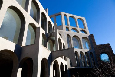 Yaratıcı açık gri beton kemerlerle dolu yapı, şekli tanımlayan sert gölgelerle, boşluklar ve odalar yaratıyor..