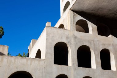 Yaratıcı açık gri beton kemerlerle dolu yapı, şekli tanımlayan sert gölgelerle, boşluklar ve odalar yaratıyor..