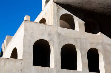 Yaratıcı açık gri beton kemerlerle dolu yapı, şekli tanımlayan sert gölgelerle, boşluklar ve odalar yaratıyor..