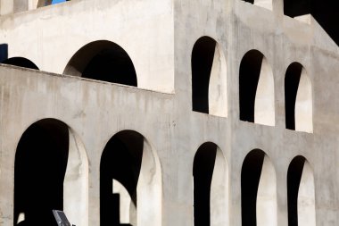 Yaratıcı açık gri beton kemerlerle dolu yapı, şekli tanımlayan sert gölgelerle, boşluklar ve odalar yaratıyor..