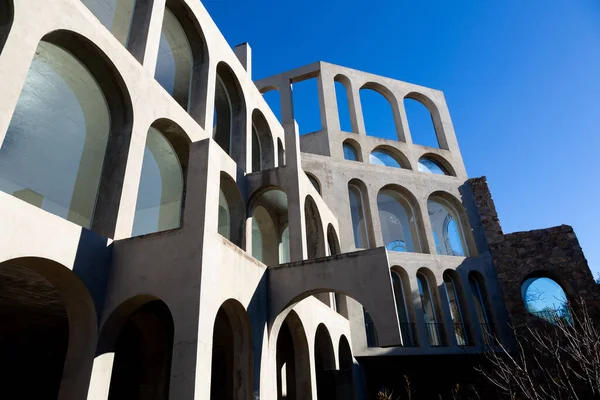 Yaratıcı açık gri beton kemerlerle dolu yapı, şekli tanımlayan sert gölgelerle, boşluklar ve odalar yaratıyor..