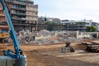 Makinelerle ve binanın enkazlarıyla bir binanın yıkılması, yeni bir bina veya kamusal alan inşa etmek için makinelerin hazırlanması.