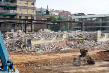 Makinelerle ve binanın enkazlarıyla bir binanın yıkılması, yeni bir bina veya kamusal alan inşa etmek için makinelerin hazırlanması.